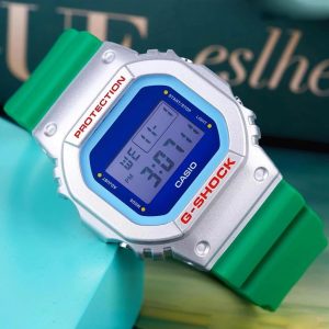 ساعت مچی دیجیتال مردانه Casio G‑SHOCK DW‑5600EU‑8A3D با قاب طوسی روشن مات، بند رزین روشن، طراحی مربعی کلاسیک، مقاومت ضربه، نور پس‌زمینه EL و مقاومت آب ۲۰۰ متر مناسب استفاده روزمره و اسپرت