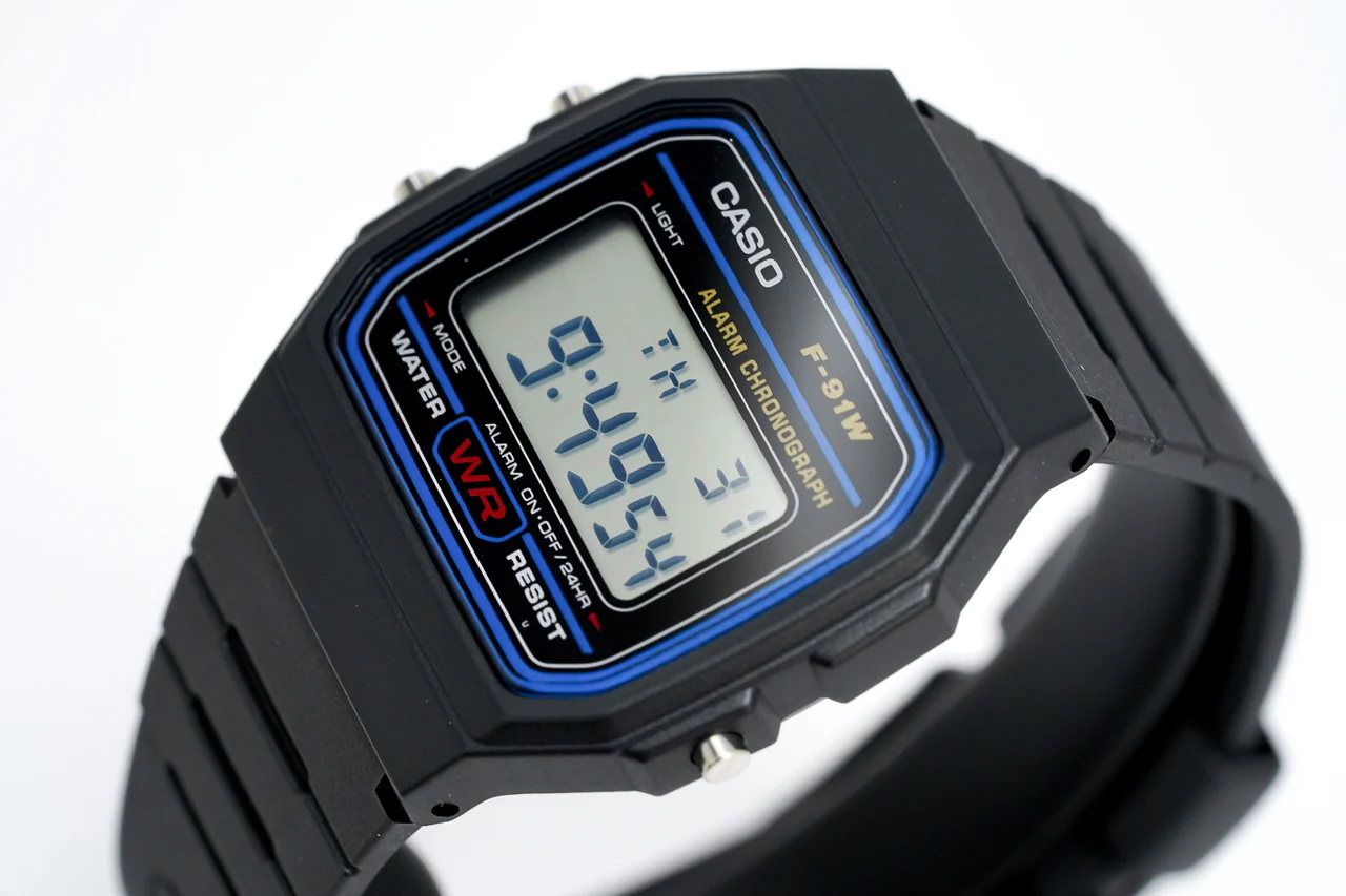 F-91W-1DG-3 ساعت مچی دیجیتال Casio F‑91W‑1DG با صفحه دیجیتال کلاسیک، قاب و بند رزین مشکی، نور پسزمینه LED، آلارم روزانه، کرنومتر و طراحی فوقسبک؛ مناسب استفاده روزمره