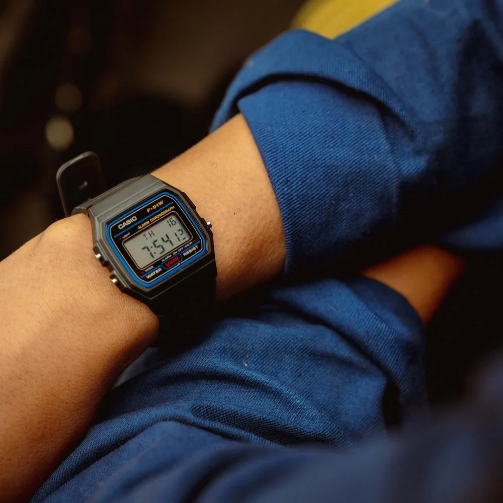 F-91W-1DG-4 ساعت مچی دیجیتال Casio F‑91W‑1DG با صفحه دیجیتال کلاسیک، قاب و بند رزین مشکی، نور پسزمینه LED، آلارم روزانه، کرنومتر و طراحی فوقسبک؛ مناسب استفاده روزمره